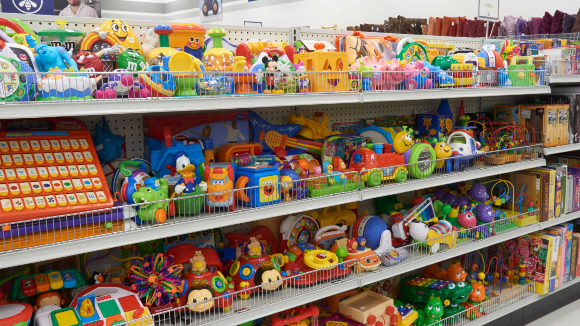 :A shelf full of colorful toys at a Deseret Industries store